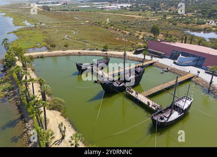 Historiquement modélisé des voiliers dans un bassin d'eau calme, entouré de paysage sous un ciel clair, vue aérienne, Muelle de las Carabelas, reproducti Banque D'Images