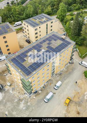 Vue aérienne montre des bâtiments avec des panneaux solaires sur les toits, chantier de construction avec plusieurs véhicules et entouré de nombreux arbres, Horb, Black Fore Banque D'Images