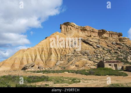 Petite cabane en face d'une colline rocheuse frappante dans un paysage désertique sous un ciel bleu, Parc naturel de Bardenas Reales, désert, semi-désert, Navarre, N Banque D'Images