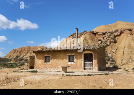 Une petite maison se dresse dans un paysage sec et rocheux sous un ciel bleu, Parc naturel de Bardenas Reales, désert, semi-désert, Navarre, Nafarroa, UNESCO, Biosphe Banque D'Images