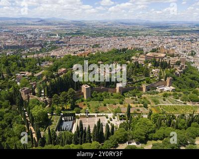 Vue aérienne d'un complexe de château, encastré dans un environnement verdoyant et entouré d'une ville et de collines, vue aérienne, Alhambra, Andalousie, Grenade, Espagne, Banque D'Images