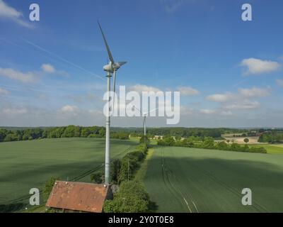 Paysage avec deux grandes éoliennes, champs environnants et arbres sous un ciel bleu avec des nuages blancs, Billerbeck Muensterland, Rhénanie du Nord-Westphal Banque D'Images