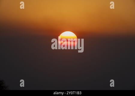 Ciel du soir avec soleil rouge au coucher du soleil, coucher de soleil derrière les nuages brumeux, Serowe, Botswana, Afrique Banque D'Images
