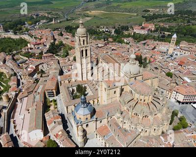 Vue panoramique d'une ville médiévale avec une église proéminente entourée de verdure campagne et de bâtiments historiques sous un ciel bleu clair, vue aérienne, Banque D'Images