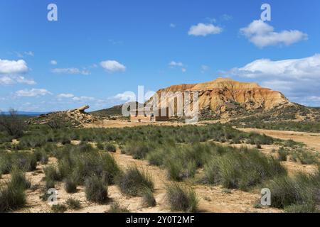 Petite cabane devant une grande colline rocheuse dans un paysage désertique sous un ciel bleu, Parc naturel de Bardenas Reales, désert, semi-désert, Navarre, Nafa Banque D'Images