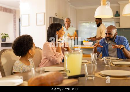 Repas et conversation, réunion familiale multigénérationnelle autour de la table à manger à la maison Banque D'Images