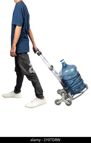 Un homme tire un chariot avec un gallon d'eau dessus. Le chariot est conçu pour transporter des bouteilles d'eau et est utilisé pour transporter la bouteille Banque D'Images