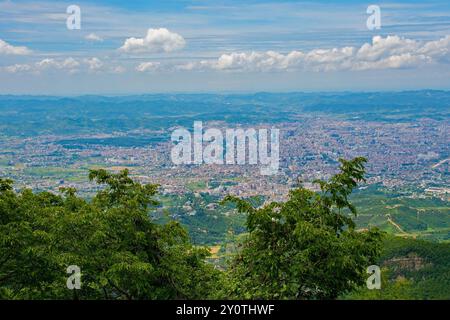 Une vue panoramique de Tirana, la capitale de l'Albanie, vue depuis le mont Dajti dans les montagnes Skanderbeg. Pentes de montagne boisées au premier plan Banque D'Images