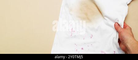 Taches sales sur un T-shirt blanc des baies et boire sur fond marron. Banque D'Images