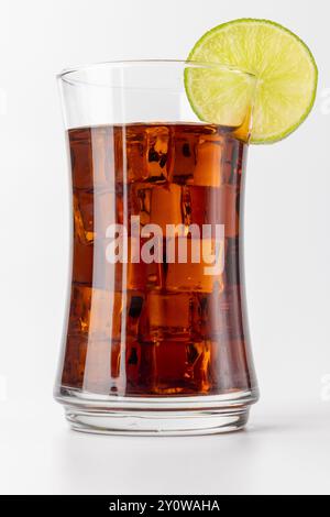 image verticale d'une boisson rafraîchissante au cola brun avec de la glace abondante et une garniture de tranche de citron. Positionnée sur la gauche, la boisson se détache contre th Banque D'Images