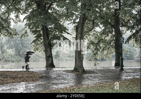 Couple sous parapluies marchant iin la pluie par la rivière Ribble à Preston Banque D'Images