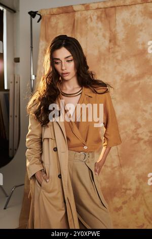 Dans un studio confortable, une jeune femme pose en toute confiance dans une tenue d'automne chic, embrassant la mode saisonnière avec charme et grâce. Banque D'Images