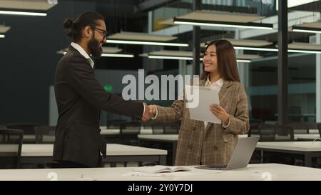 Femme asiatique coréenne fille d'affaires chinoise femme d'affaires japonaise femme d'affaires contrat de succès contrat document poignée de main serrer les mains Arabian Banque D'Images