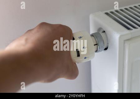 Réglage du thermostat sur la main du radiateur Banque D'Images