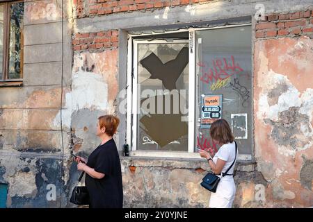 Lviv, Ukraine. 04th Sep, 2024. LVIV, UKRAINE - 4 SEPTEMBRE 2024 - deux femmes passent devant une fenêtre brisée par l'onde de choc de l'attaque de missiles russes dans le district de Zaliznychnyi à Lviv, dans l'ouest de l'Ukraine. Dans les premières heures du mercredi 4 septembre, les envahisseurs russes ont lancé une attaque de missiles sur Lviv tuant sept personnes, dont deux enfants, et blessant 53 personnes. Crédit : Ukrinform/Alamy Live News Banque D'Images