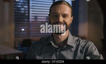 Caucasien souriant toothy mâle des années 30 heureux sourire homme d'affaires propriétaire de petite entreprise insouciant homme positif regardant la caméra au bureau du soir à l'intérieur Banque D'Images