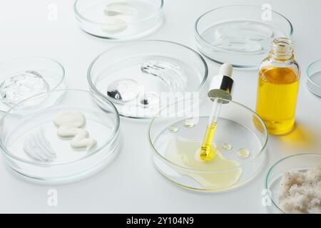 Boîtes de Petri avec différents produits cosmétiques sur fond blanc, gros plan Banque D'Images