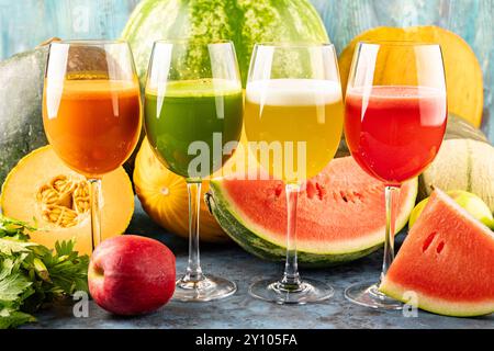 Pastèque et melon jus de boisson frais dans les verres. La boisson est sur un fond bleu avec un demi melon d'eau, céleri et pomme dans le backgro Banque D'Images