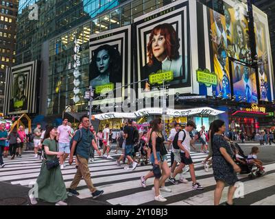 Des hordes de gens traversent West 42nd Street sous la publicité pour les Warner Bros PicturesÕ ÒBeetlejuice BeetlejuiceÓ le mercredi 14 août 2024. Le film, réalisé par Tim Burton, devrait sortir le 6 septembre 2024 (© Richard B. Levine) Banque D'Images