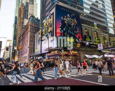 Des hordes de gens traversent West 42nd Street sous la publicité pour les Warner Bros PicturesÕ ÒBeetlejuice BeetlejuiceÓ le mercredi 14 août 2024. Le film, réalisé par Tim Burton, devrait sortir le 6 septembre 2024 (© Richard B. Levine) Banque D'Images