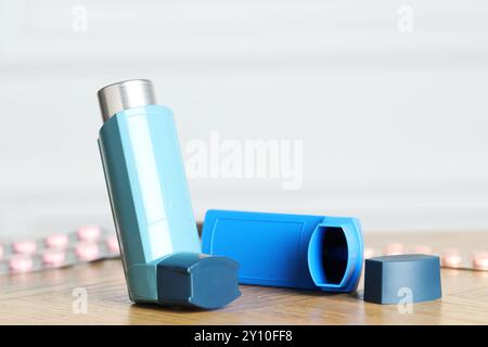 Inhalateurs sur la table en bois à l'intérieur, gros plan avec espace pour le texte. Traitement de l'asthme Banque D'Images
