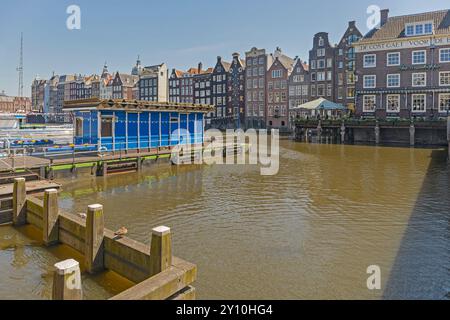 Amsterdam, pays-Bas - 14 mai 2018 : maisons traditionnelles sur l'eau côté est du centre-ville de Damrak au printemps. Banque D'Images