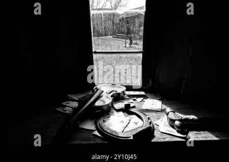 Un petit musée historique près du parc national de Zion. Une vieille guitare, des outils de travail dispersés sur la table. Le noir et blanc dessinaient leur silhouette. Banque D'Images