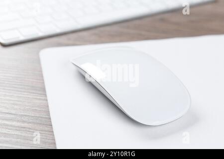 Souris d'ordinateur avec tapis de souris et clavier sur le bureau en bois, gros plan Banque D'Images