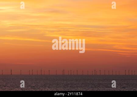 Angleterre, Kent, Kingsgate Bay, Sunrise Over Sea avec éoliennes en distance Banque D'Images