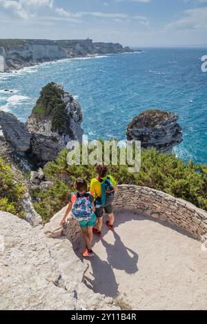 Deux touristes admirant le panorama du détroit de Bonifacio, avec Capo Pertusato en arrière-plan. Bonifacio, Corse du Sud, Corse, France Banque D'Images