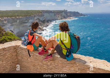 Deux touristes admirant le panorama du détroit de Bonifacio, avec Capo Pertusato en arrière-plan. Bonifacio, Corse du Sud, Corse, France Banque D'Images