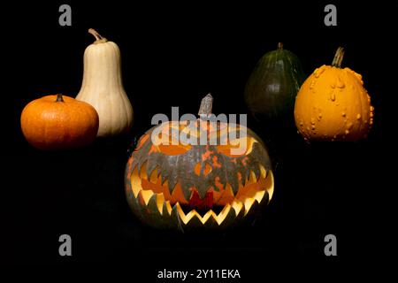 Une citrouille au visage effrayant est entourée d'autres citrouilles. La scène est effrayante et sur le thème d'Halloween Banque D'Images