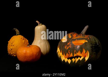 Une citrouille au visage effrayant est entourée d'autres citrouilles. La scène est effrayante et sur le thème d'Halloween Banque D'Images