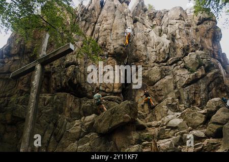 On voit des grimpeurs monter la paroi rocheuse dans le secteur de Sukiennice, avec un grimpeur solo libre visible sur la droite, dans la région d'escalade de Sokoliki dans la basse-Silésie Voïvodie, dans le sud-ouest de la Pologne. La région d'escalade de Sokoliki (également connue sous le nom de Soko?y ou Góry Sokole) est très populaire parmi les grimpeurs. La région est située dans le sud-ouest de la Pologne, à environ 15 km de la ville de Jelenia Góra. Pendant la saison chaude, les grimpeurs de Pologne et de l'étranger visitent la région pour gravir les rochers de granit. Banque D'Images