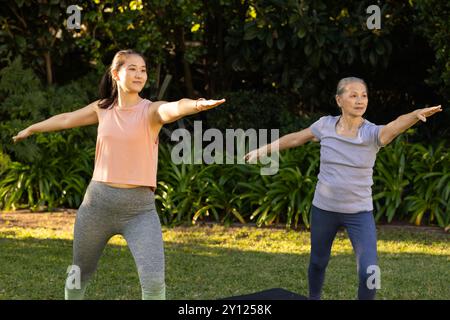 Pratiquer le yoga en plein air, grand-mère asiatique et petite-fille profitant de la routine de fitness dans le jardin Banque D'Images