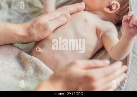 La peau du nouveau-né pèle. Maman utilise des produits pour la peau et des massages pour soigner et apaiser la peau délicate du bébé, assurant confort et promotion Banque D'Images