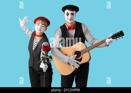 Couple de pantomimistes avec rose et guitare sur fond bleu Banque D'Images