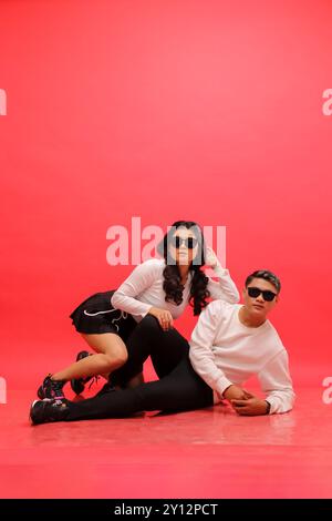 jeune couple asiatique élégant portant des chandails blancs, lunettes de soleil penchées vers le bas. pour romance, mariage, publicité, contenu promotionnel Banque D'Images