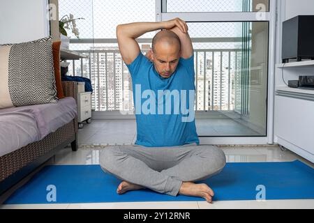 Homme brésilien de 48 ans pratiquant le yoga chez lui 4. Banque D'Images