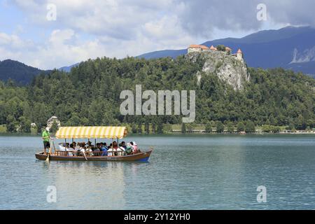 SLOVÉNIE, BLED, 15 JUILLET 2019 : bateau touristique traditionnel. Beau lac de montagne en été avec château sur falaise et alpes en arrière-plan Banque D'Images