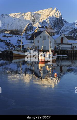 Bateaux de pêche dans le fjord devant les montagnes enneigées, lumière du matin, hiver, Reine, Moskenesoya, Lofoten, Norvège, Europe Banque D'Images