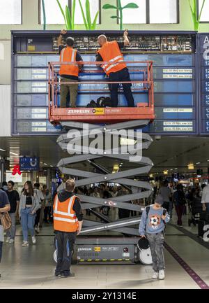 Techniciens travaillant sur un panneau d'information électronique, panneau d'affichage pour les liaisons ferroviaires à la gare centrale de Duesseldorf, Rhénanie du Nord-Westphalie, GE Banque D'Images