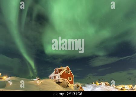 Aurores boréales, aurores boréales au-dessus de la maison rouge, établissement inuit, hiver, Tasiilaq, est du Groenland, Groenland, Amérique du Nord Banque D'Images