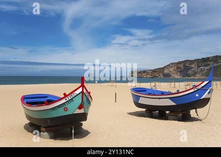 Deux bateaux de pêche sur la plage de sable de Nazare avec vue sur la mer et les falaises, plage de Praia da Nazare, Nazare, Oeste, quartier Leiria, Centro, E Banque D'Images