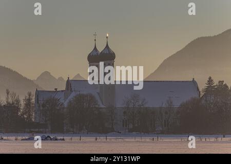 Monastère et basilique dans la lumière du soir en face des montagnes, neige, hiver, monastère Benediktbeuern, contreforts alpins, haute-Bavière, Bavière, G Banque D'Images