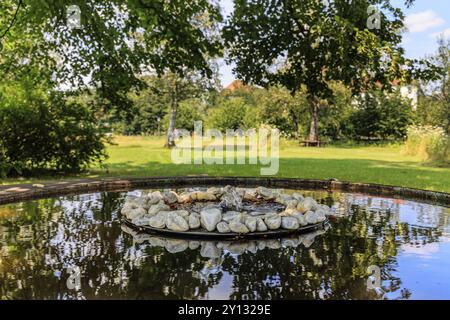 Petite fontaine et bol d'eau avec des pierres sous les arbres, monastère de Schlehdorf, Bavière, Allemagne, Europe Banque D'Images