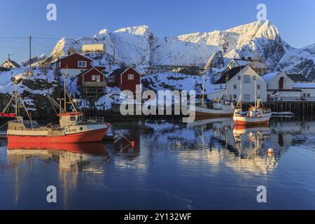 Bateaux de pêche dans le fjord devant les montagnes enneigées, lumière du matin, hiver, Reine, Moskenesoya, Lofoten, Norvège, Europe Banque D'Images