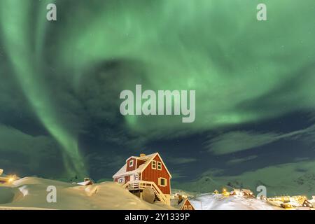 Aurores boréales, aurores boréales au-dessus de la maison rouge, établissement inuit, hiver, Tasiilaq, est du Groenland, Groenland, Amérique du Nord Banque D'Images