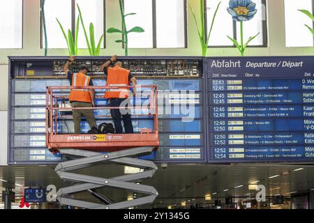 Techniciens travaillant sur un panneau d'information électronique, panneau d'affichage pour les liaisons ferroviaires à la gare centrale de Duesseldorf, Rhénanie du Nord-Westphalie, GE Banque D'Images