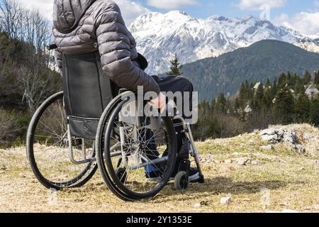 Jeune homme handicapé en fauteuil roulant à l'extérieur dans la nature l'observation de montagne et la nature Banque D'Images